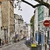 Calle empedrada de París en pendiente entre edificios haussmanianos con contraventanas y farolas