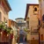 Calle estrecha de un casco antiguo español con casas ocres, balcones de forja y tejados de tejas